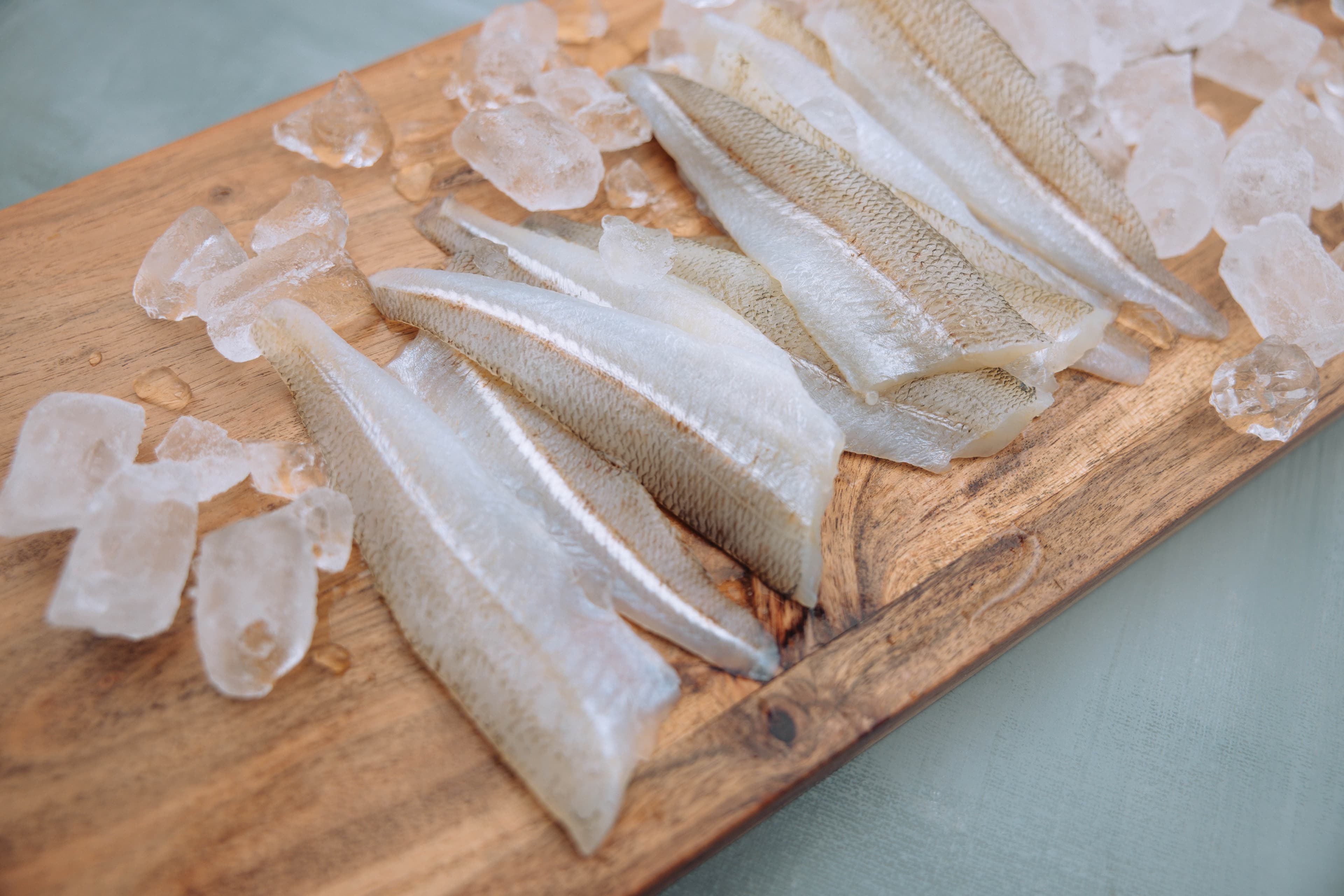 Fresh single Eastern School Whiting fillets in retail tray on wooden table